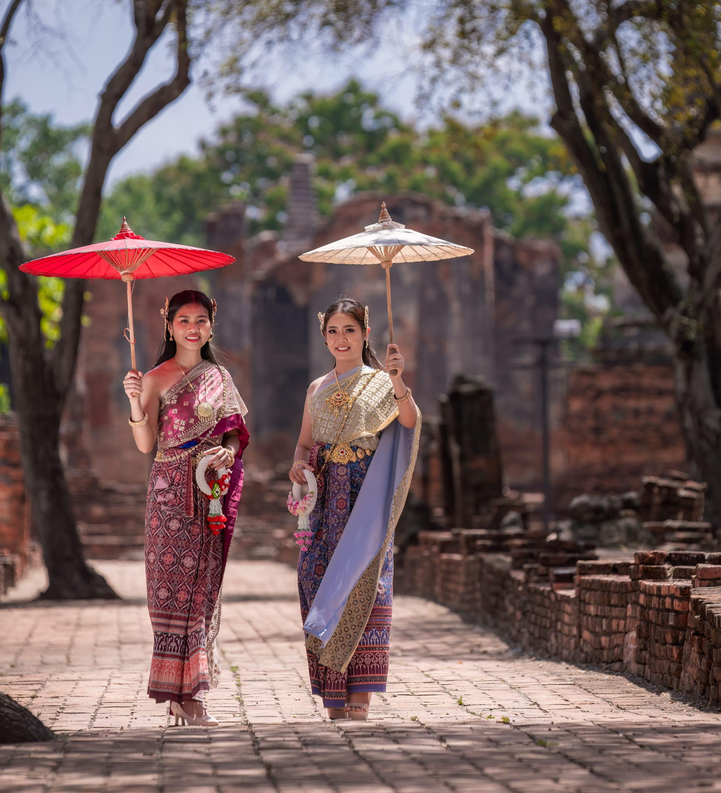 Travellers with parasols in a temple courtyard